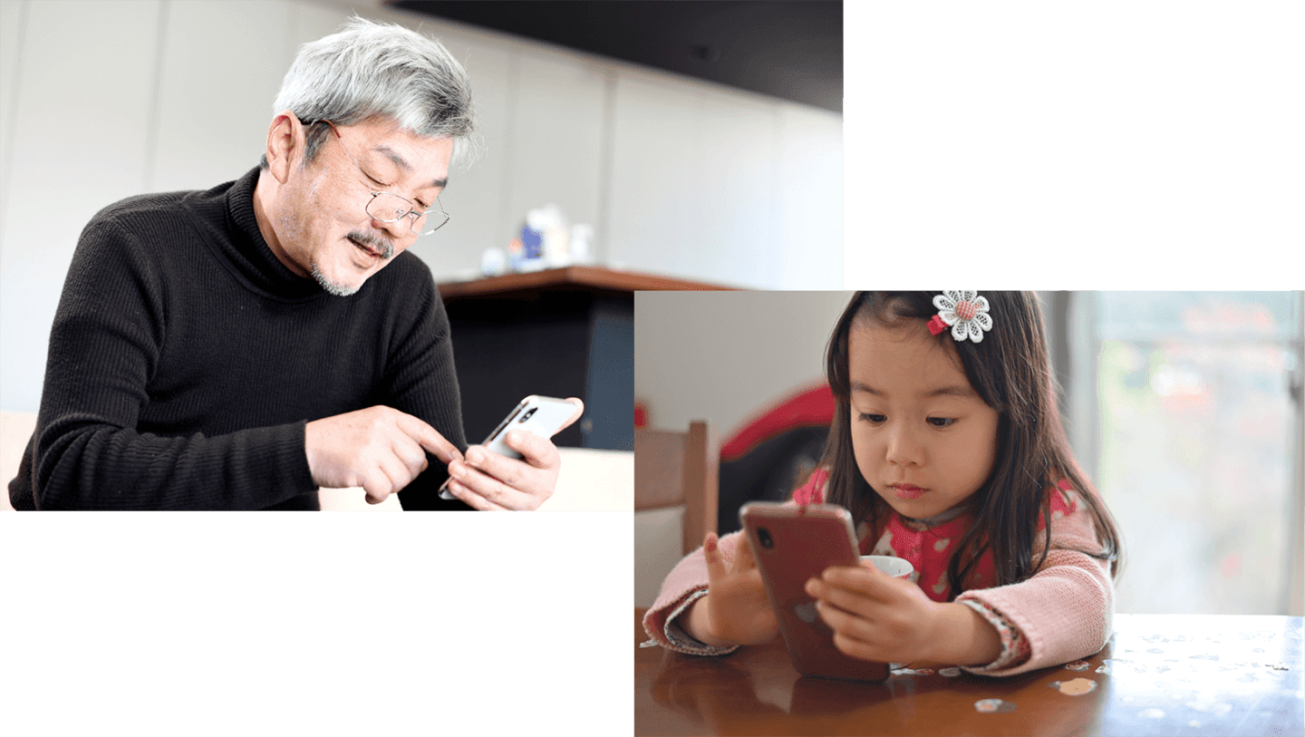 高齢者と子供がスマートフォンを操作しているイメージ写真